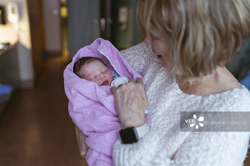 新奶奶抱着她的孙子在病房里图片素材