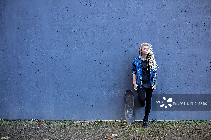 带着滑板的年轻女子，在户外图片素材