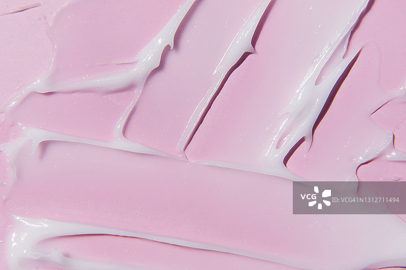 液体凝胶霜质地在粉红色的背景。图片素材
