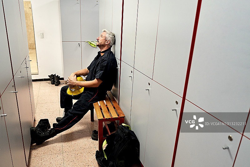 成熟的男性消防员在消防站更衣室休息图片素材