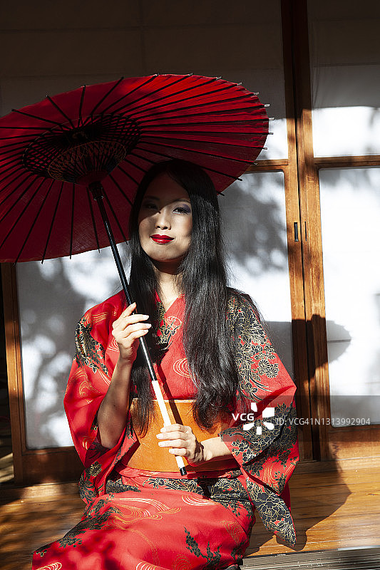 穿着和服和红伞的美丽日本女人图片素材