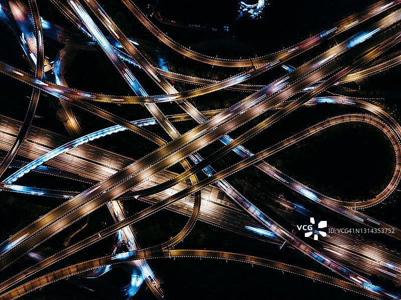鸟瞰图的复杂天桥和繁忙的交通在夜间图片素材