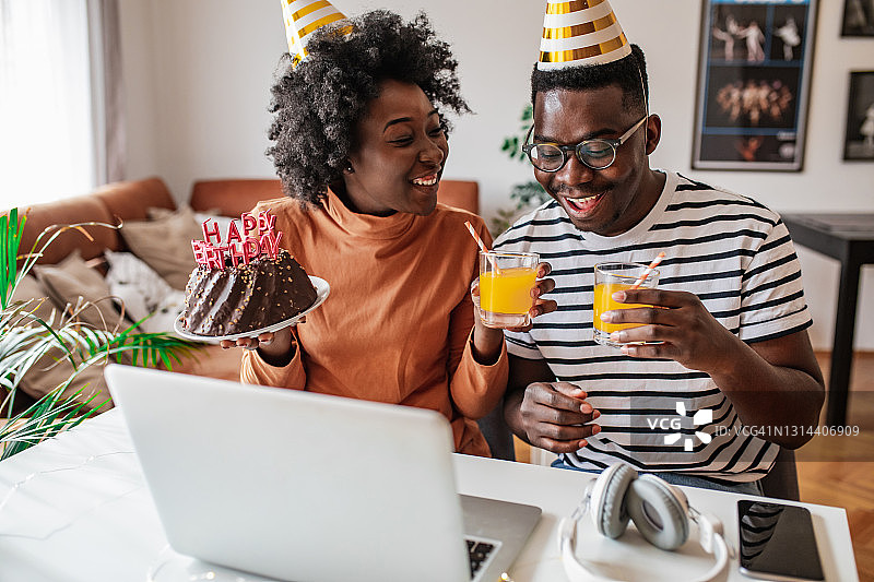 一对非裔美国夫妇在视频通话中与朋友庆祝生日图片素材