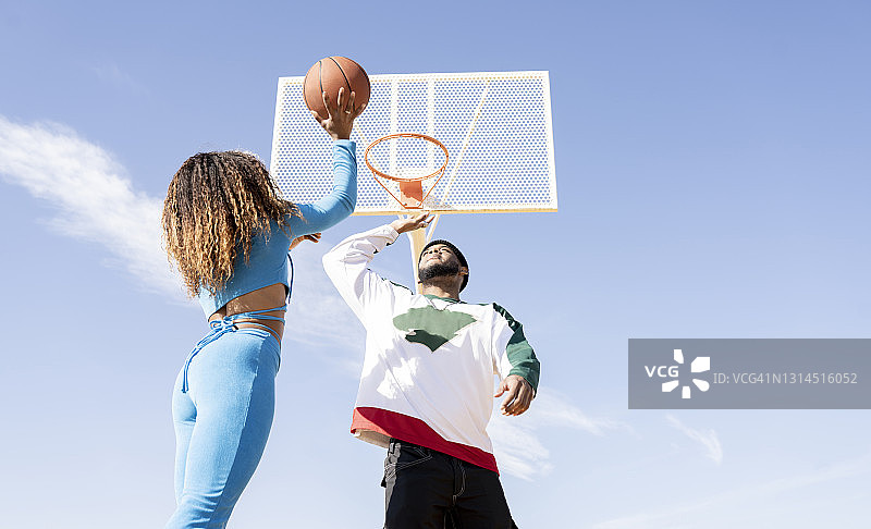 男性和女性在运动场上打篮球图片素材