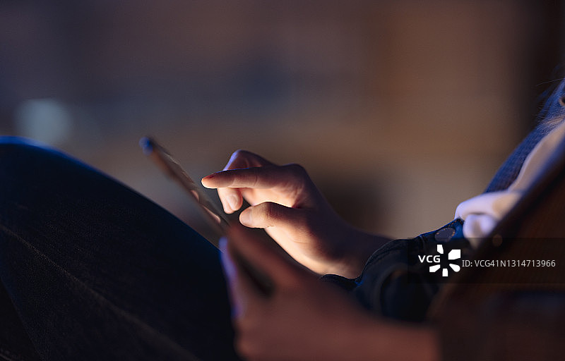 一位匿名女性触摸着发光的平板电脑屏幕图片素材
