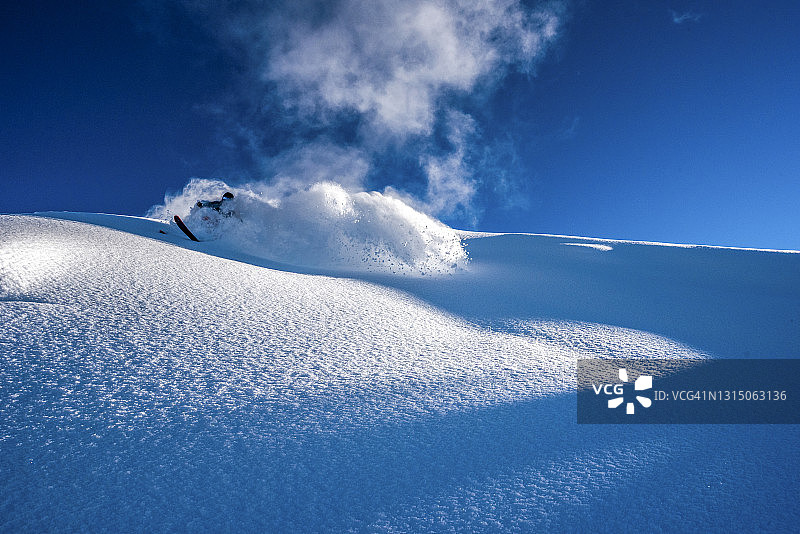 滑雪者从陡峭的山脊上滑下图片素材