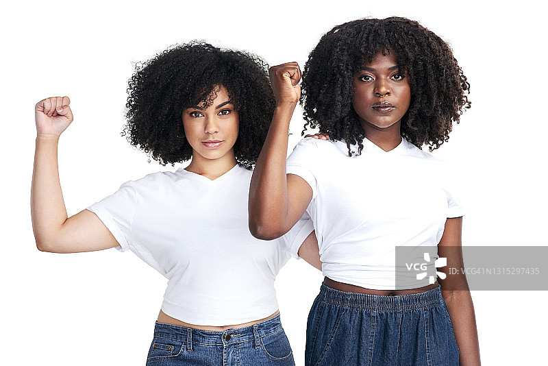 在一个白色的背景下，两名年轻女子举起拳头以示团结图片素材