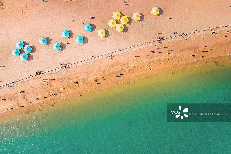 鸟瞰图黄海沐浴在黄沙上的沙滩伞，大连，中国。图片素材