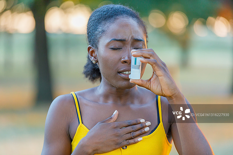 年轻的非裔美国女性在户外的大自然中有哮喘的问题。图片素材