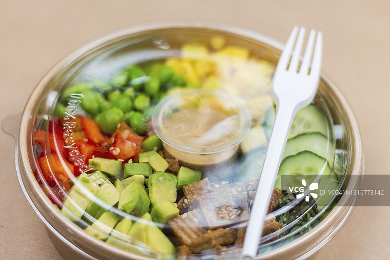 一个在塑料容器中的健康午餐的特写，在棕色的背景上。图片素材