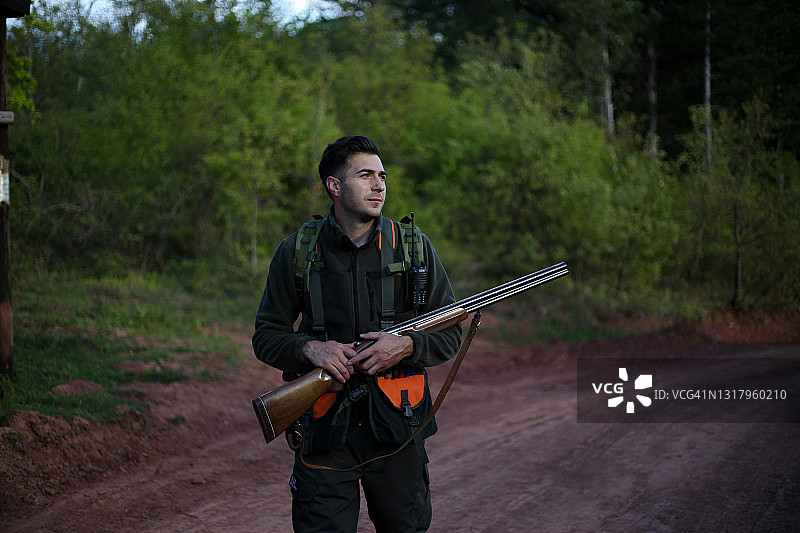 猎人带着步枪在森林照片中行走图片素材