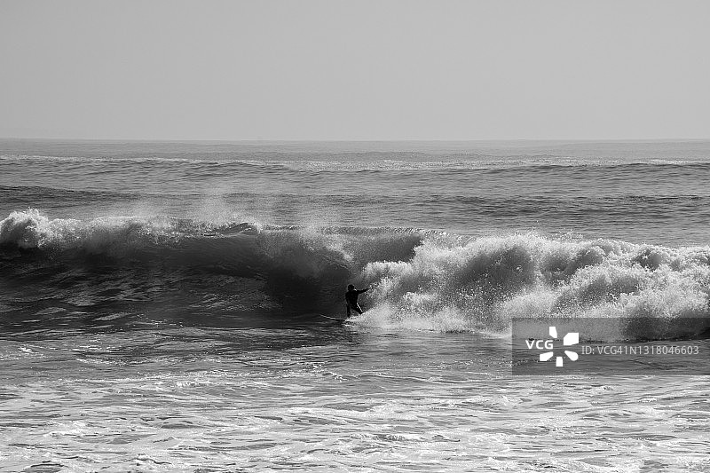 一名男子在里斯本冲浪的黑白照片图片素材