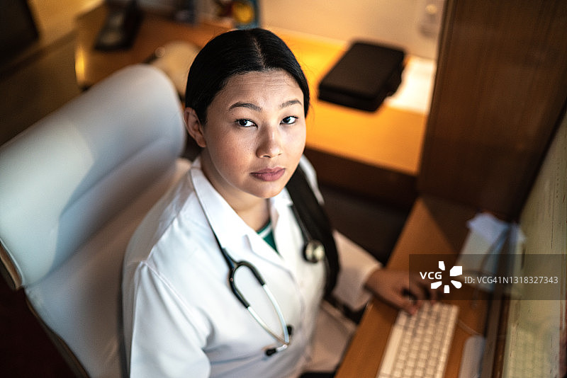 一位年轻女医生在医院使用电脑工作的肖像图片素材