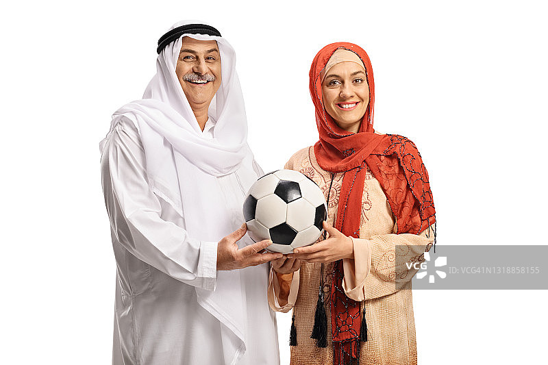 一个成熟的穆斯林男子和一个年轻女子手拿足球在一起图片素材
