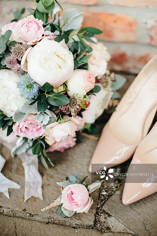 婚礼饰品:新郎胸花、新娘花束和米色高跟鞋。有选择性的重点。图片素材