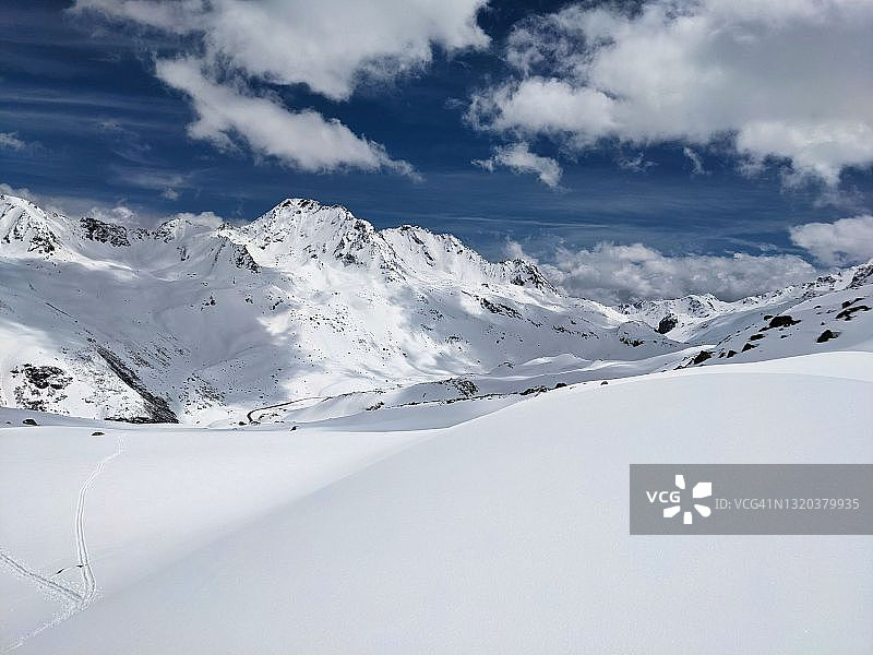 在美丽的grisons山滑雪之旅。冬季探险，在雪多的山上徒步旅行。蓝色天空的太阳图片素材