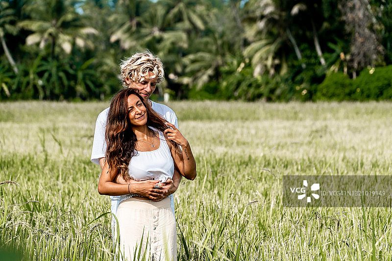 斯里兰卡，日出时分，一对幸福的情侣在草地上拥抱在一起图片素材