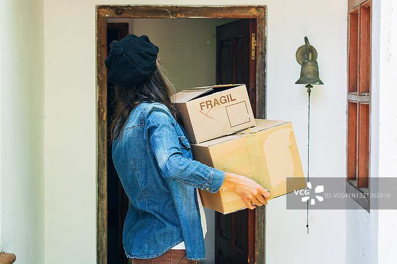一个女人拿着两个纸箱的特写镜头。搬家图片素材
