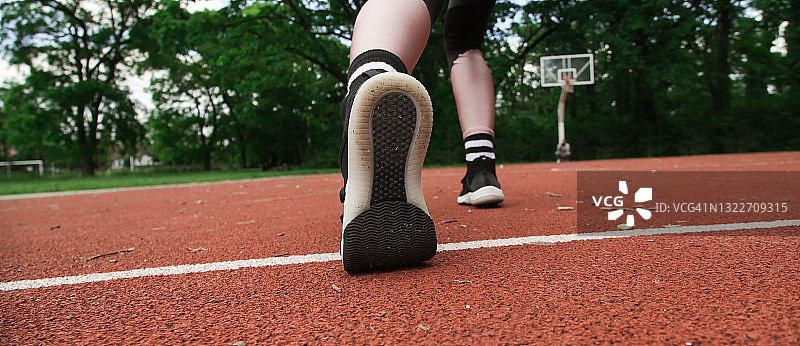 一个运动员在运动场上的运动鞋的特写。户外活动与运动，定格行动。图片素材