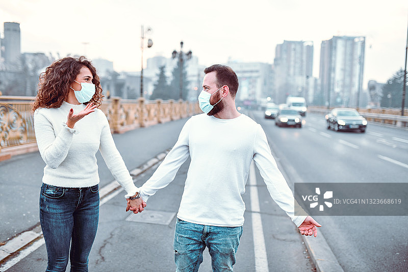 戴口罩的夫妇在城市里戴口罩游行抗议污染图片素材