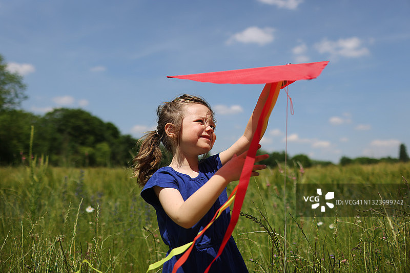 一个女孩在田野里玩风筝图片素材