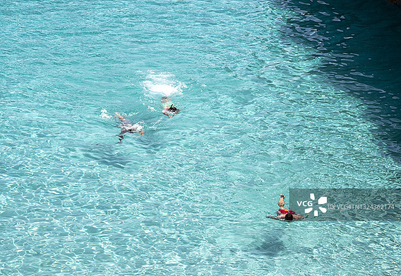 在马略卡岛的卡拉德尔莫罗，人们在地中海透明的水中游泳和跳水。图片素材