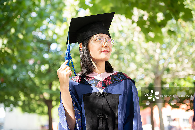 穿着毕业礼服的亚洲女人，漂亮的中国女毕业生图片素材
