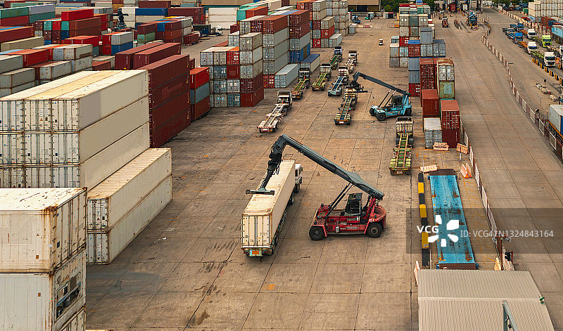 在配送仓库用叉车将集装箱装到集装箱卡车上，用于运输到集装箱船，商务物流，进出口运输或货运。图片素材