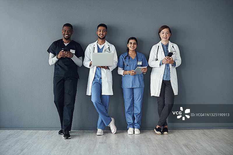 一群医生站在灰色背景下工作的照片图片素材