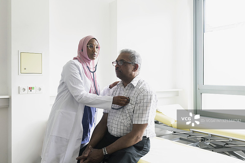 女穆斯林医生用听诊器检查老年男子的心脏图片素材