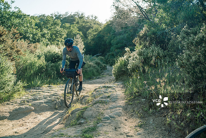 一个年轻人在乡村的路上骑自行车图片素材