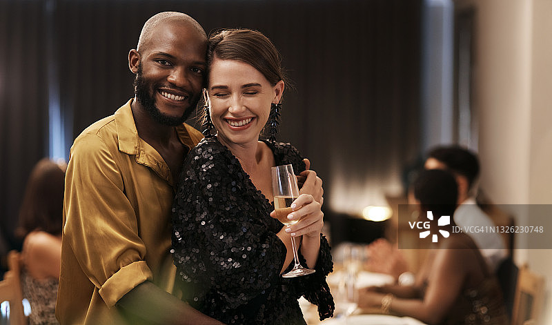 这是一对幸福的年轻夫妇在新年晚宴上紧紧站在一起的照片图片素材