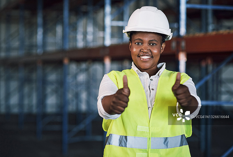 一个年轻女人在建筑工地竖起大拇指工作的肖像图片素材