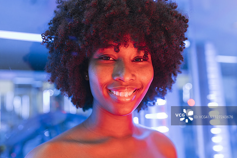 微笑的年轻女子脸上挂着霓虹灯图片素材