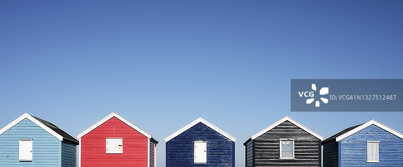 蓝天映衬下的五颜六色的海滩小屋图片素材