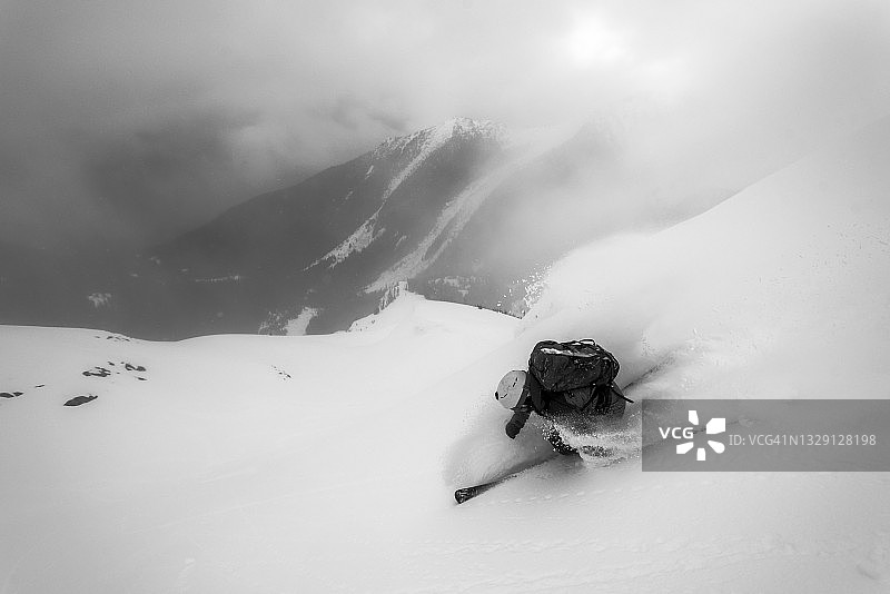 偏远地区的滑雪者从雪坡上滑下来图片素材
