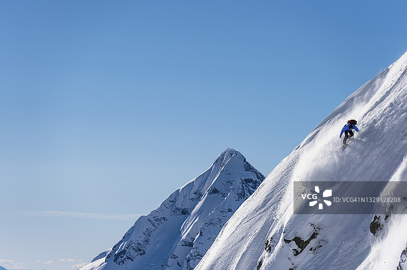 滑雪者准备从雪山山脊上跳下图片素材