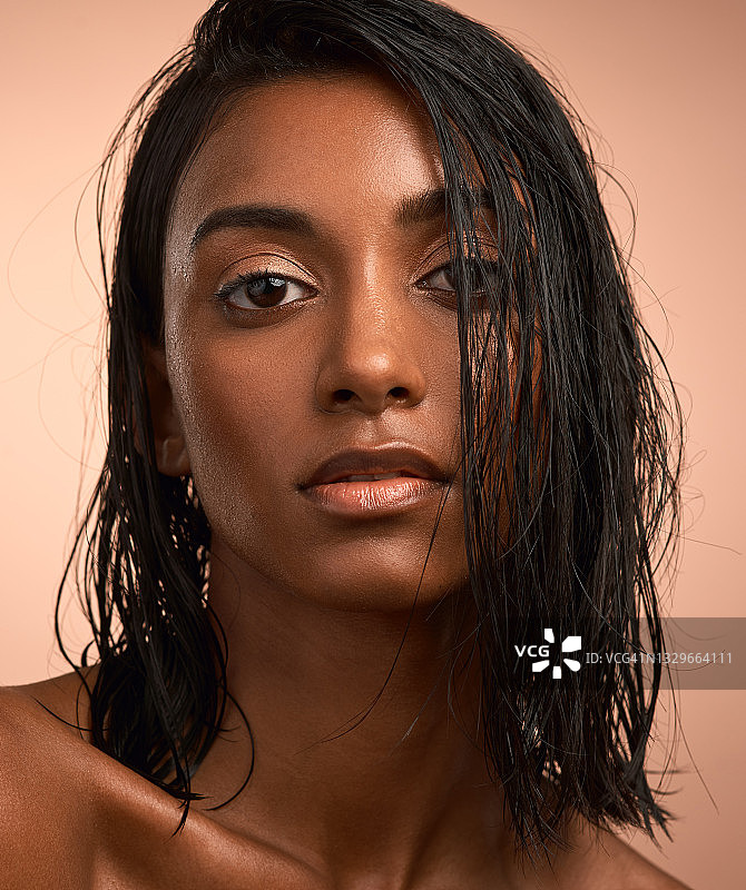 一个美丽的年轻女子的肖像后，有一个清爽的淋浴在一个棕色的背景图片素材