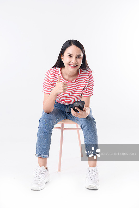 女人坐在椅子上用智能手机图片素材