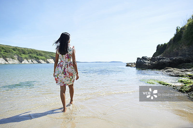 美丽的亚洲女人在夏天走在海滩上。图片素材