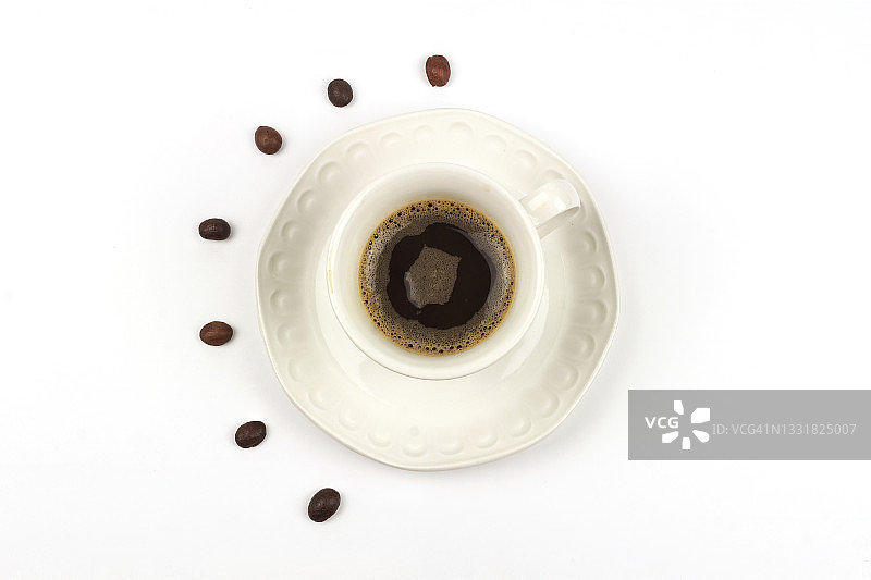 白色背景上的咖啡杯和咖啡豆的高角度视图。图片素材