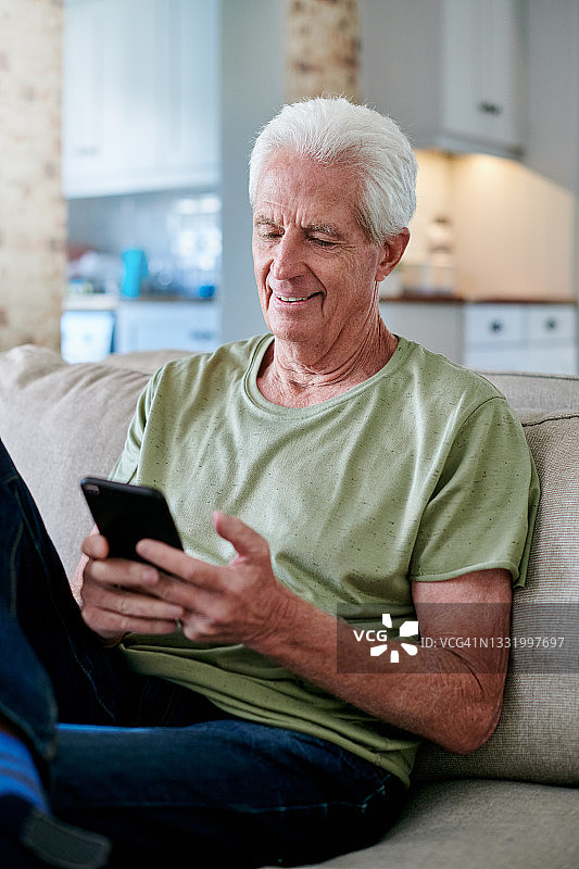 一名老人坐在家里用手机图片素材