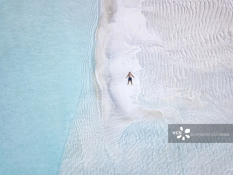 鸟瞰图上的孤独的人日光浴沙滩上的萨鲁德胡岛图片素材