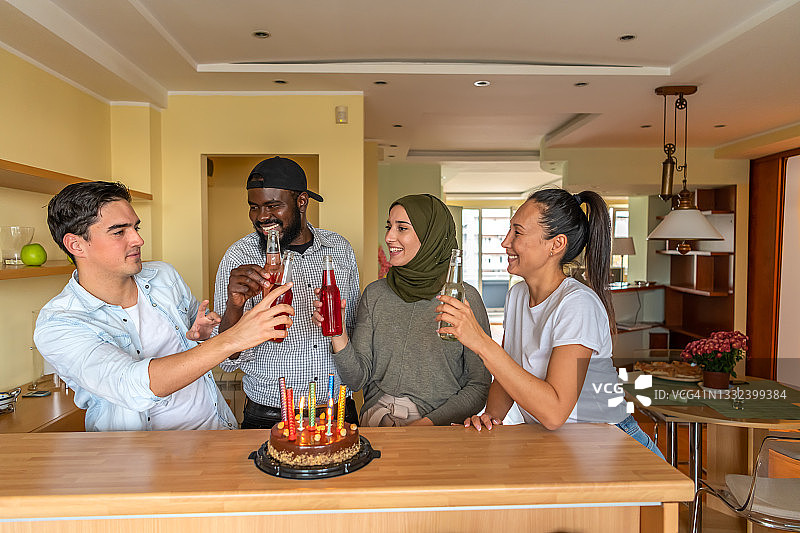一群不同种族的朋友很高兴在家里一起度过一个生日派对。图片素材