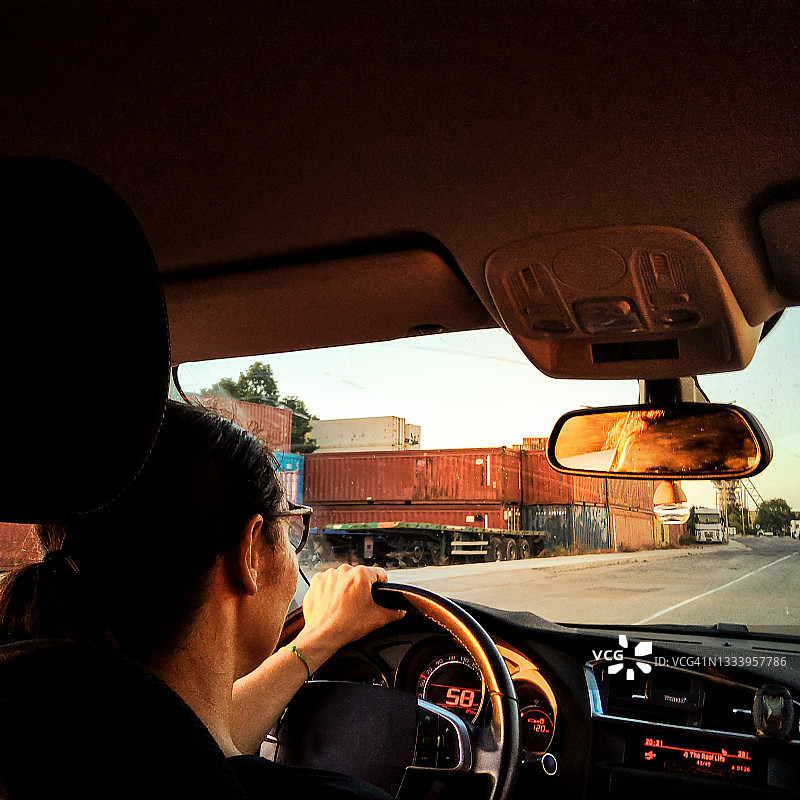 一位职业妇女在日落时分开车上班图片素材