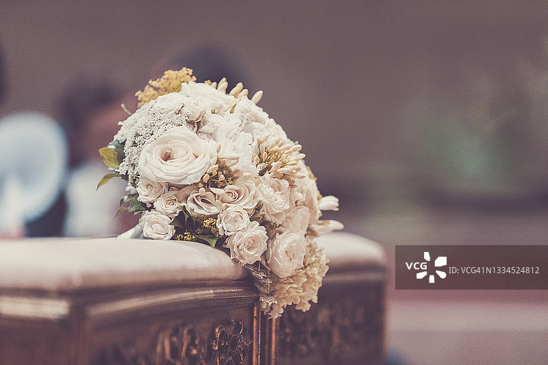 在意大利伦巴第举行的婚礼上，放在教堂长凳上的新娘花束图片素材