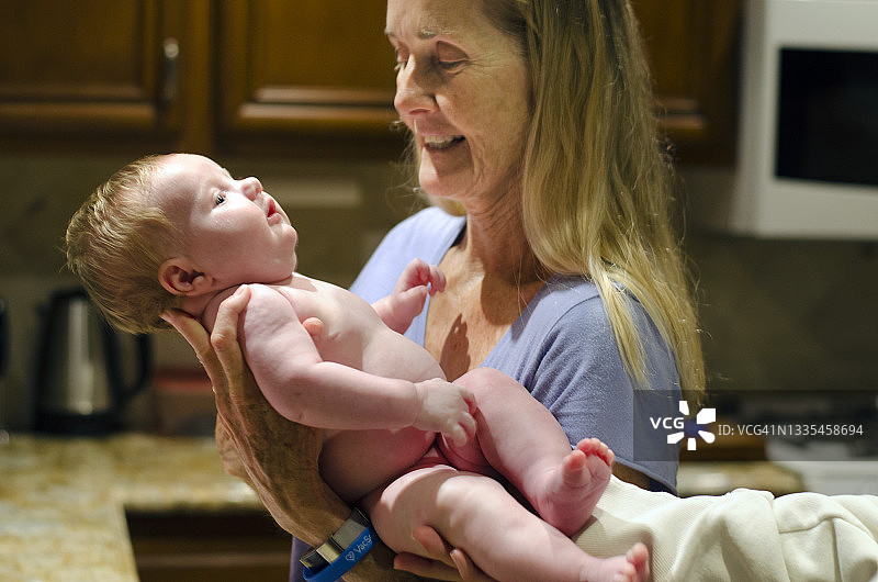 快乐的外婆抱着新生儿图片素材