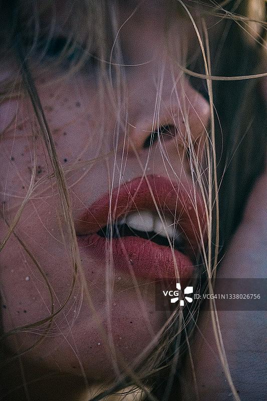 一个女人的嘴唇充满激情的宏观特写，红唇和湿润的脸。表现出激情和性感。图片素材