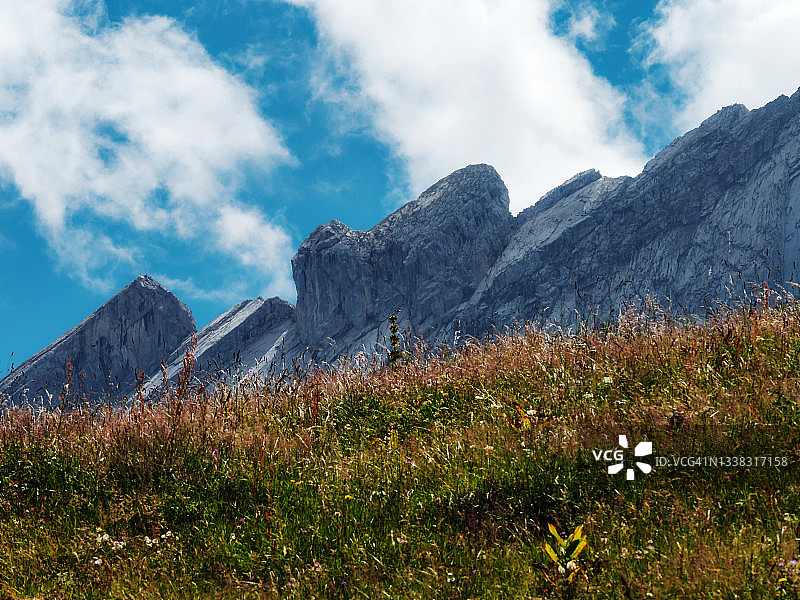 瑞士阿尔卑斯山的绝美悬崖。云朵，山峰上的雪和瀑布。夏天。图片素材
