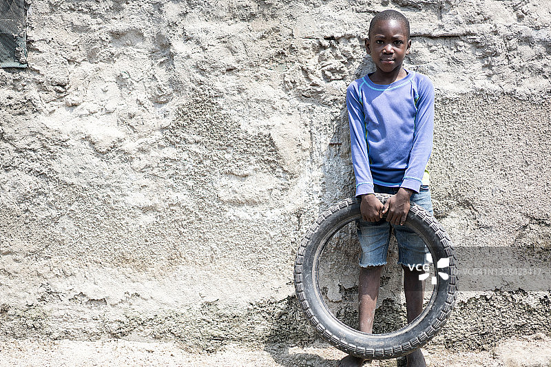 可怜的非洲男孩拿着轮胎玩具图片素材